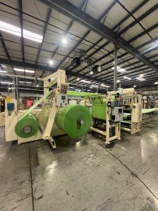 A large roll of thin green foam hanging on a rack.